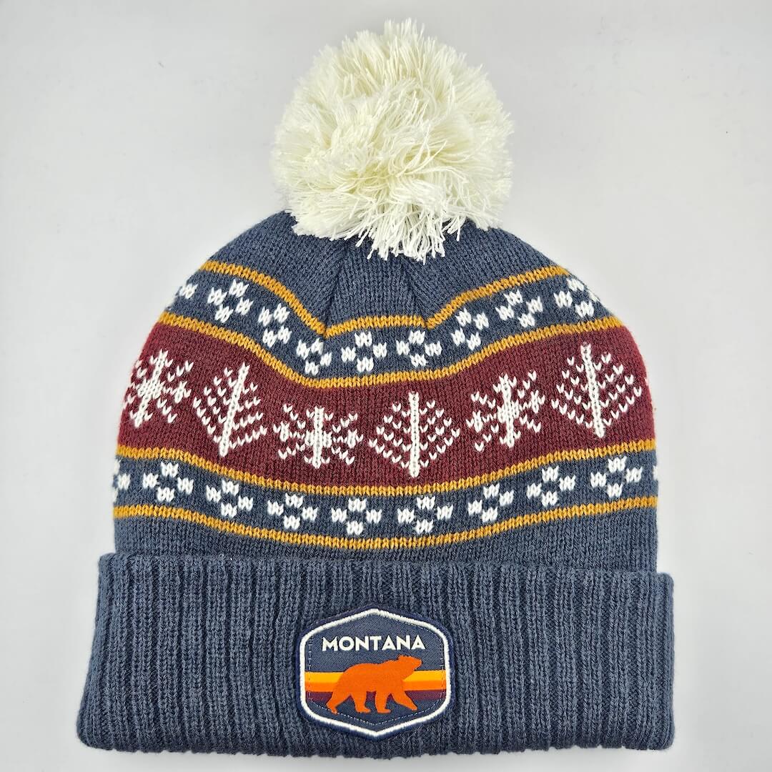 Knitted beanie with pom-pom and Montana logo on a light gray background