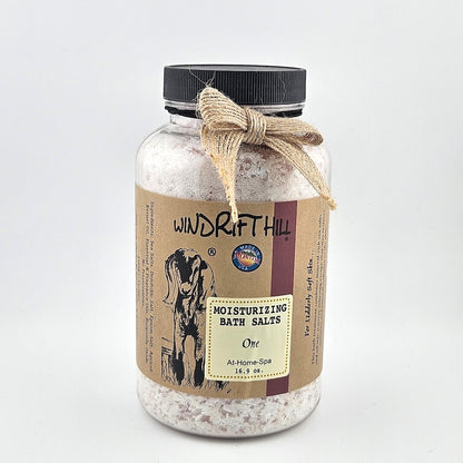 Jar of Windrift Hill bath salts with a decorative ribbon on a gray background