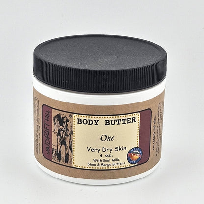 Jar of body butter with a black lid on a gray background