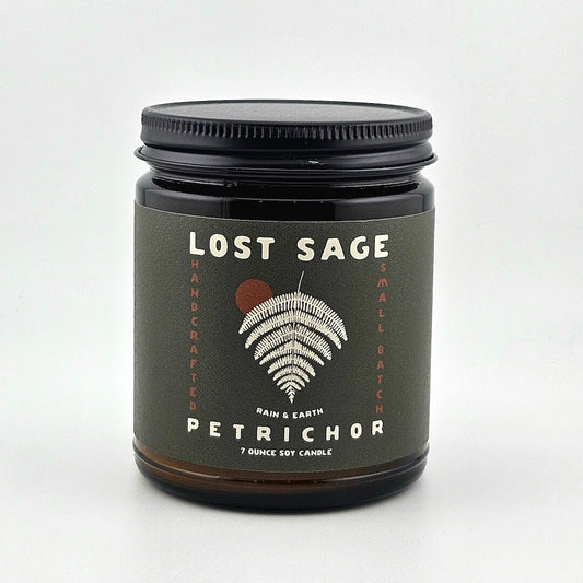 Candle jar labeled 'Lost Sage, Petrichor' on a white background
