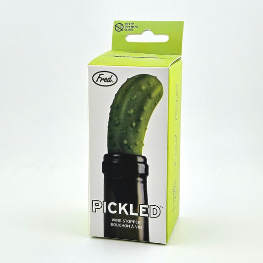 Green and white packaging for pickle shaped wine stopper against white background.