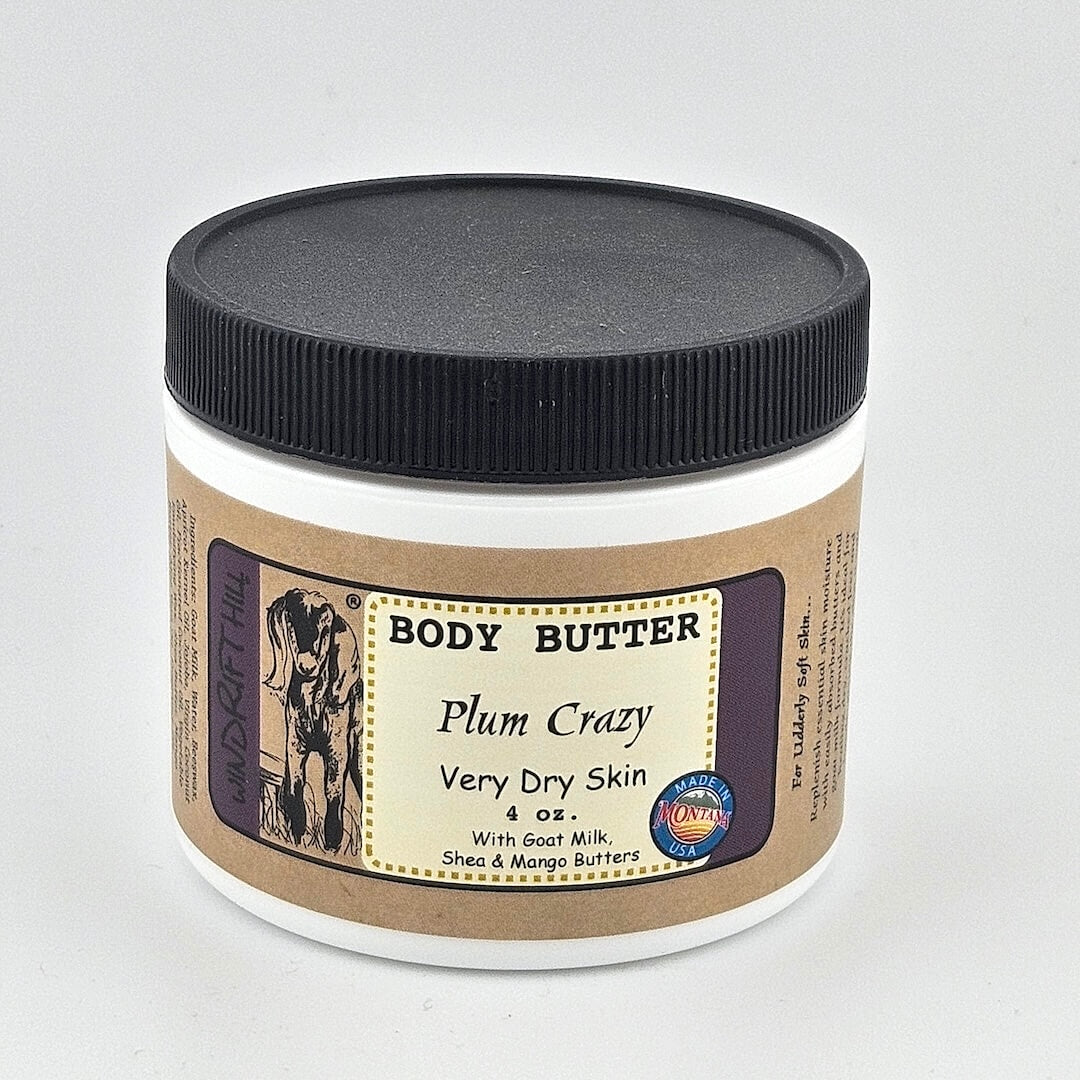 Jar of body butter labeled 'Plum Crazy' on a gray background