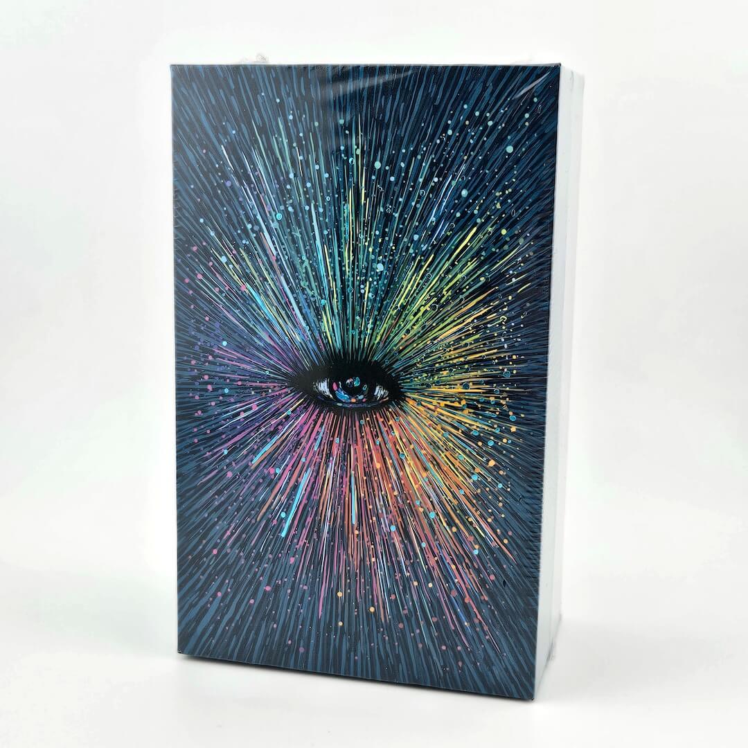 Tarot deck with eye in center with colorful rays emanating from it. 