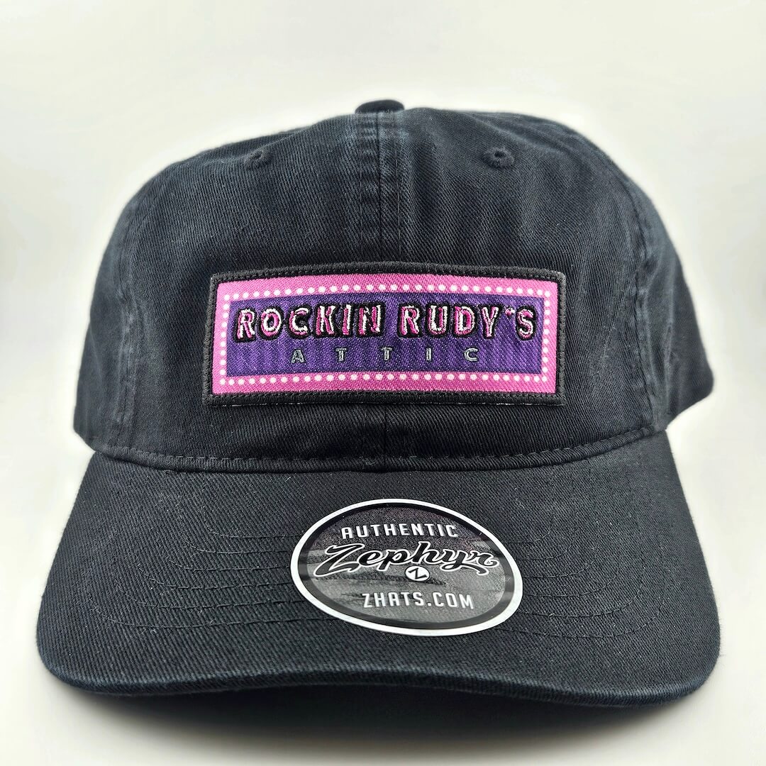 Black cap with 'Rockin Rudy's Attic' patch on a white background