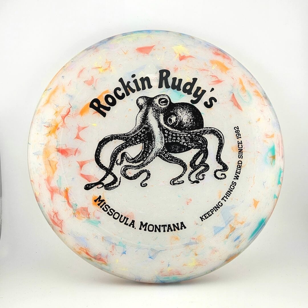 Multicolored frisbee with white main body, image of octopus in center with, "Rockin Rudy's" above, location & motto below. 