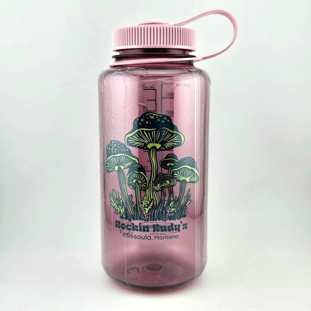 Light pink water bottle with matching lid. Green mushrooms as center image with stars on tops, store name & location below. 