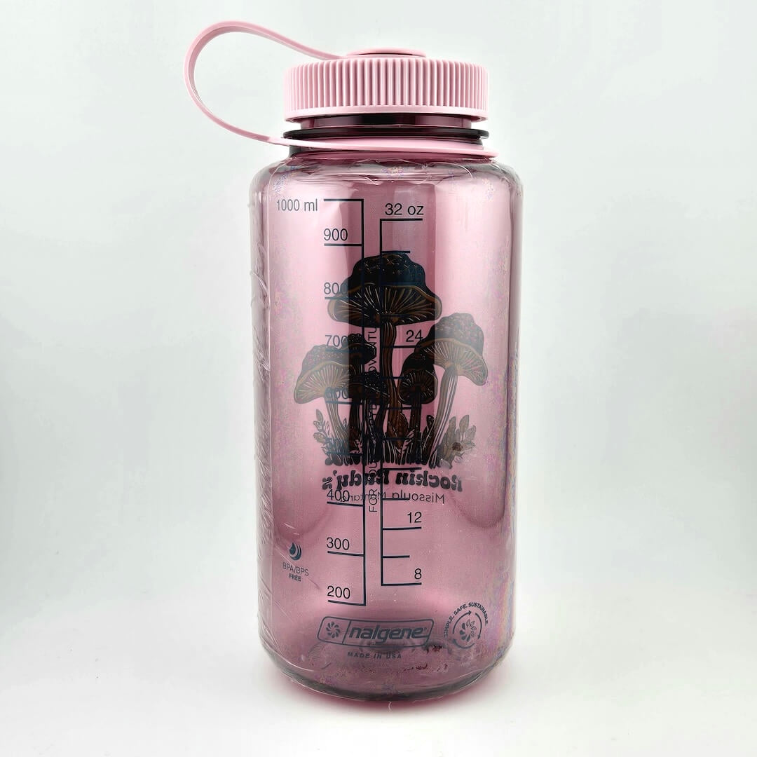 Light pink water bottle with matching lid. Green mushrooms as center image with stars on tops, store name & location below. 