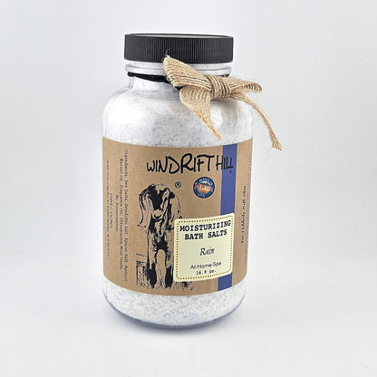 Jar of Windrift Hill bath salts with a decorative ribbon on a gray background