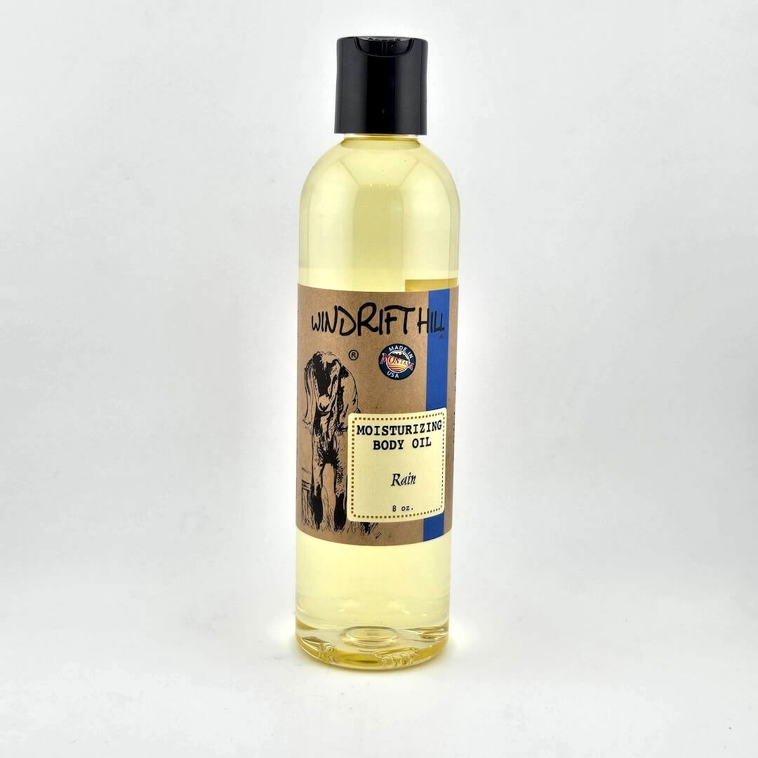 Plastic bottle of Windrift Hill moisturizing body oil on a gray background