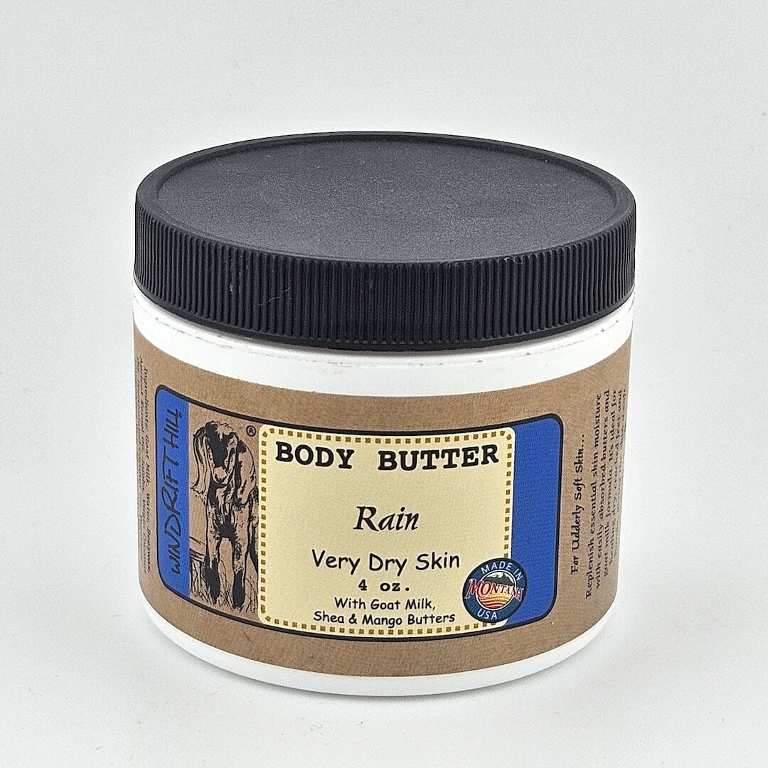 Jar of body butter labeled 'Rain' for very dry skin on a gray background