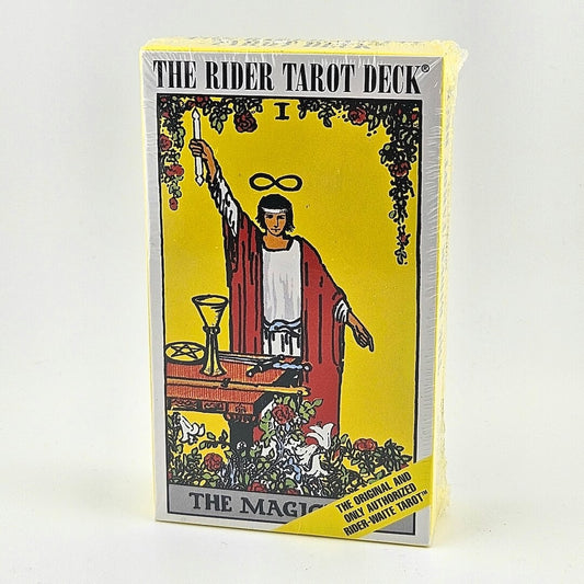 White and yellow box of tarot cards with classical image of The Magician on front. Magician in red robe raising hand by table. 
