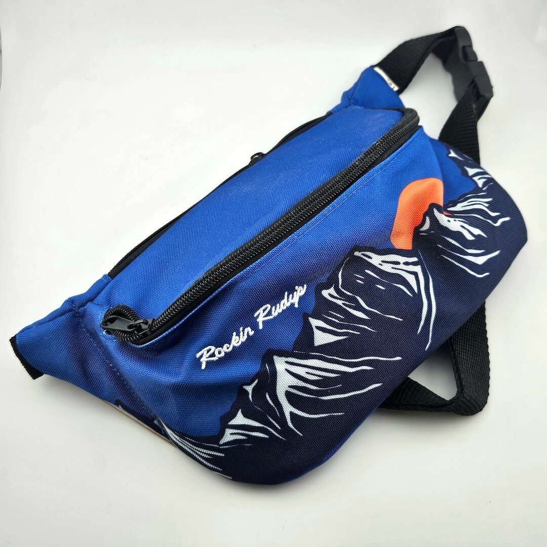 Blue fanny bag with mountain landscape across main body under white text, "Rockin Rudys"