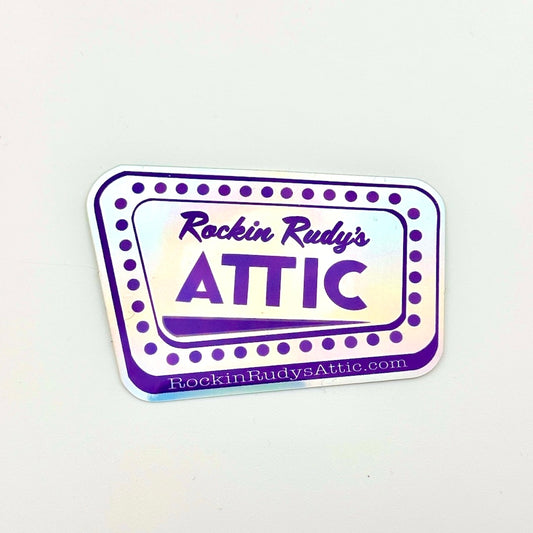 Holographic sticker with 'Rockin Rudy's Attic' text on a white background