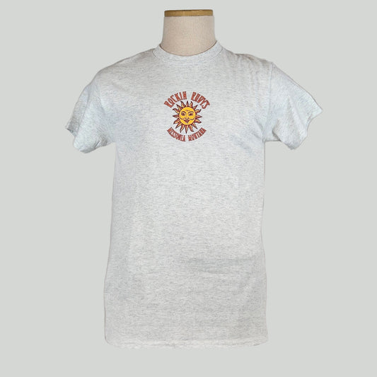 Heathered gray colored t-shirt with small sun in center with "ROCKIN RUDY'S" & "MISSOULA, MONTANA" encircling it. 