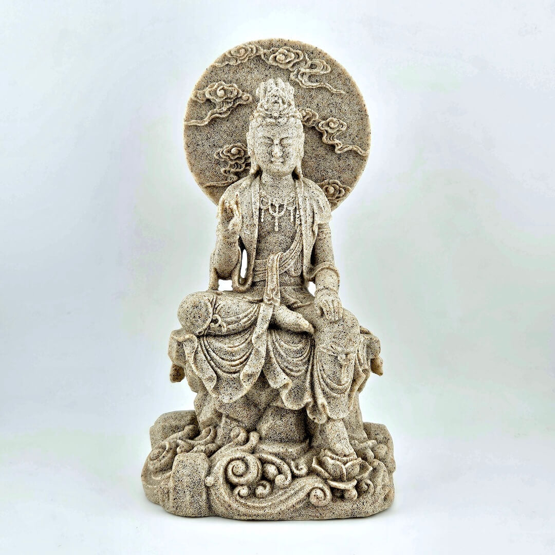 Statue of a seated figure with intricate details on a white background
