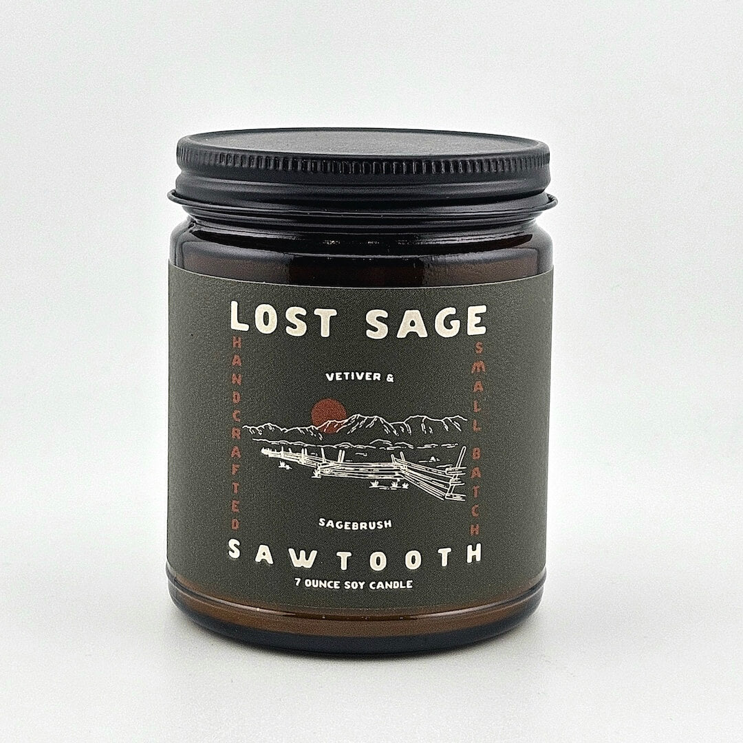 Candle jar labeled 'Lost Sage' with a mountain design on a white background