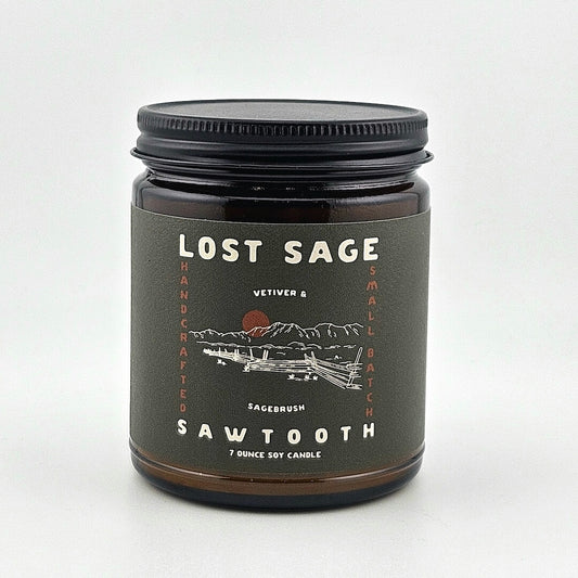 Candle jar labeled 'Lost Sage' with a mountain design on a white background