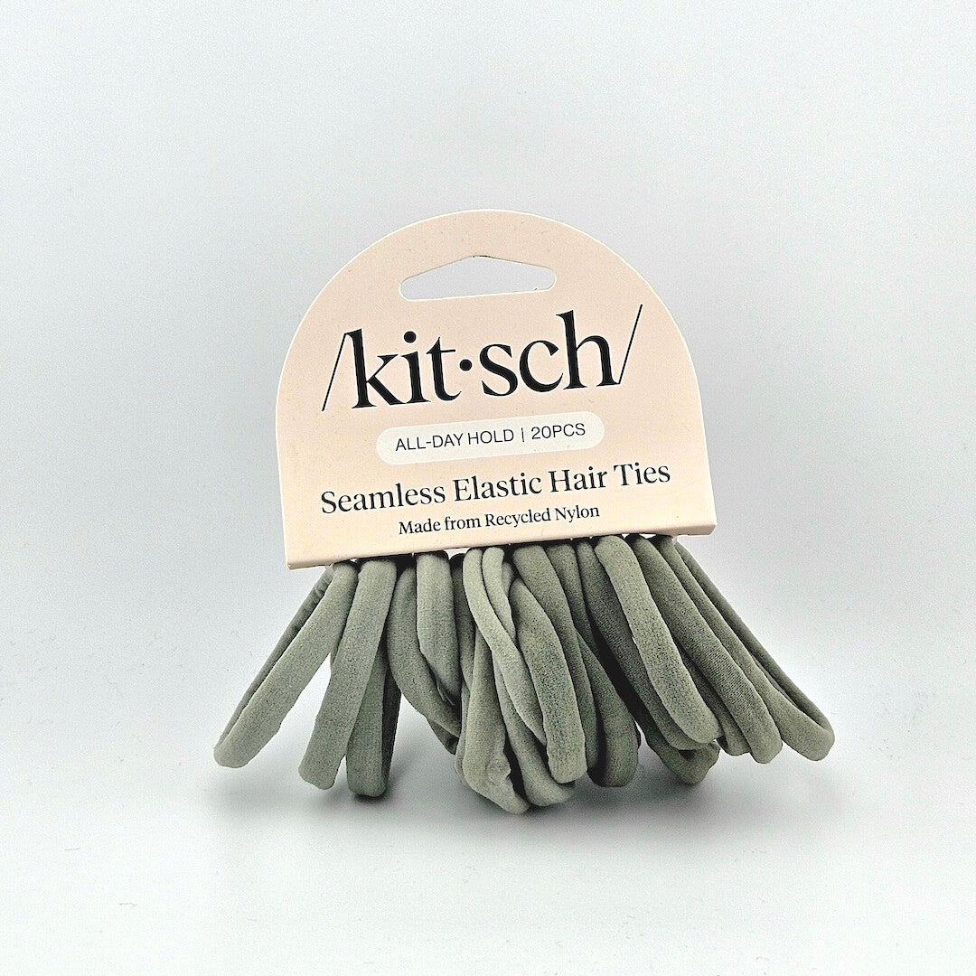 Green elastic hair ties with pink packaging against white background. 