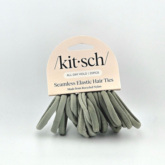 Green elastic hair ties with pink packaging against white background. 