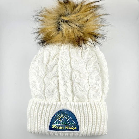 White knit beanie with fur pom-pom and logo on a light gray background