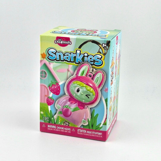 Brightly colored packaging for plastic creature charms against gray background. 