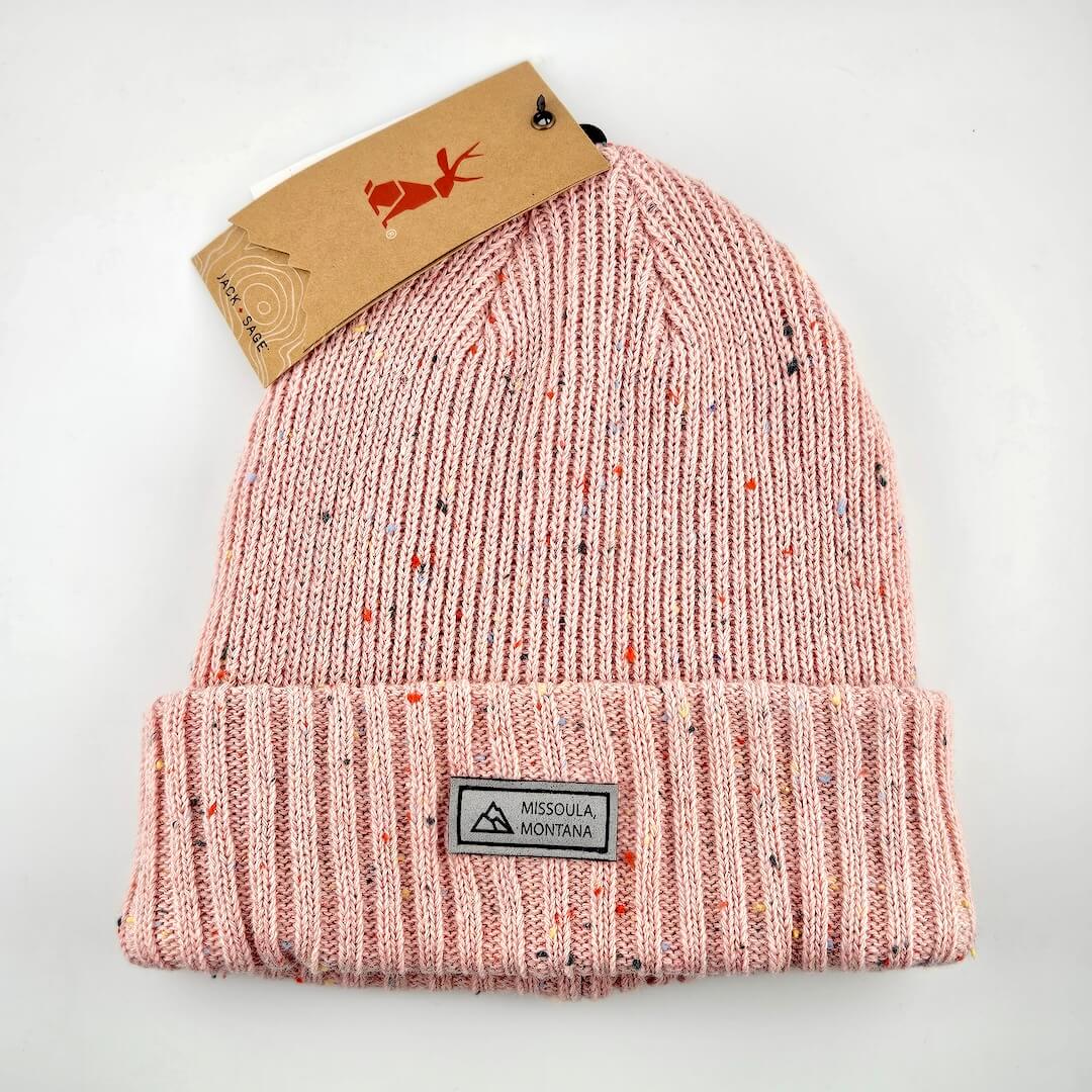 Pink speckled beanie with a tag on a white background