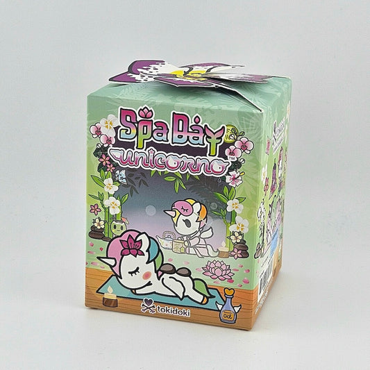 Brightly colored packaging for blind box unicorn figure against gray background. 