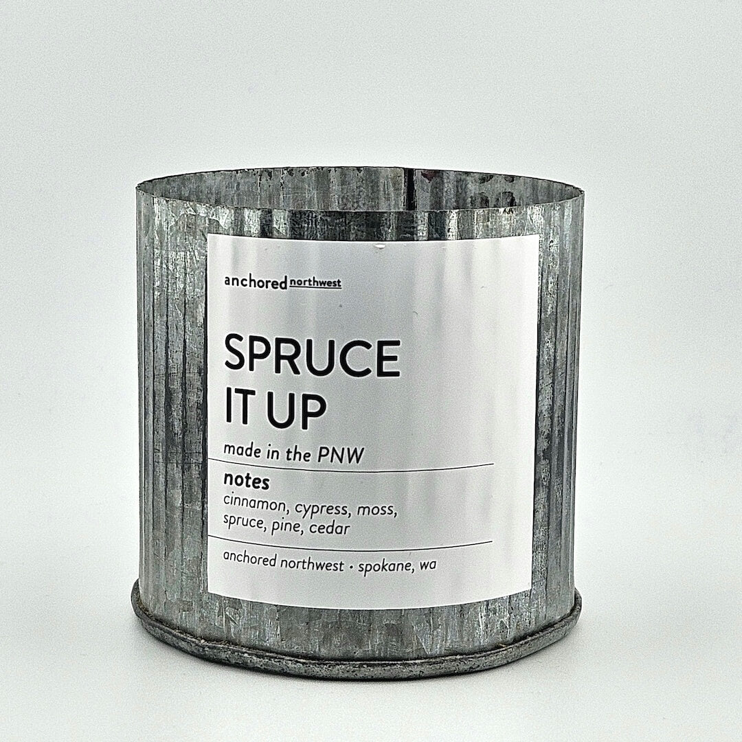 Candle in a metal container with a label on a white background
