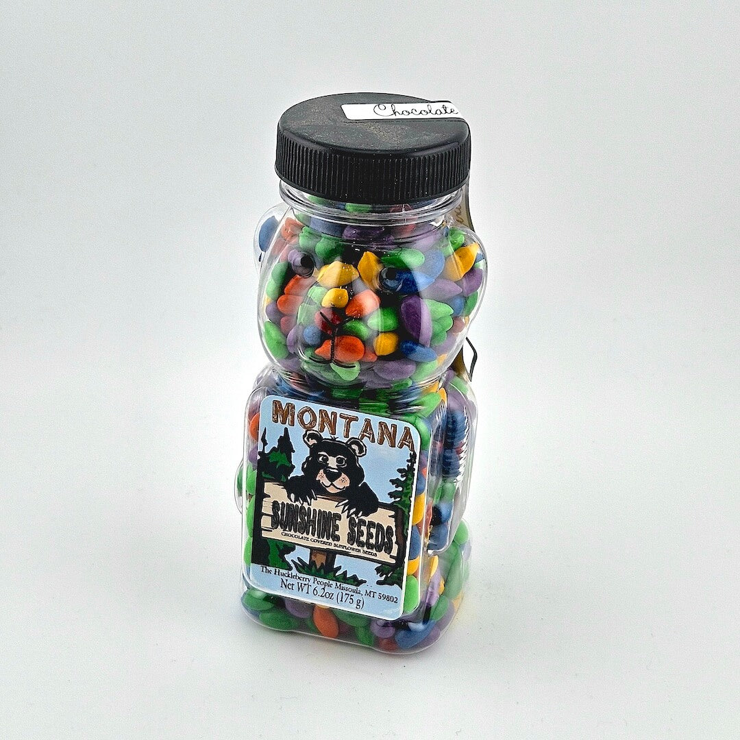 Jar of colorful candies with Montana Sunshine Seeds label on a white background