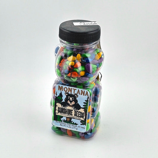 Jar of colorful candies with Montana Sunshine Seeds label on a white background