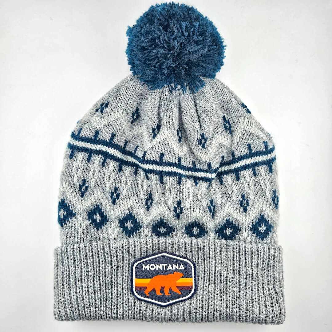 Gray knit beanie with blue pom-pom and Montana logo on a white background