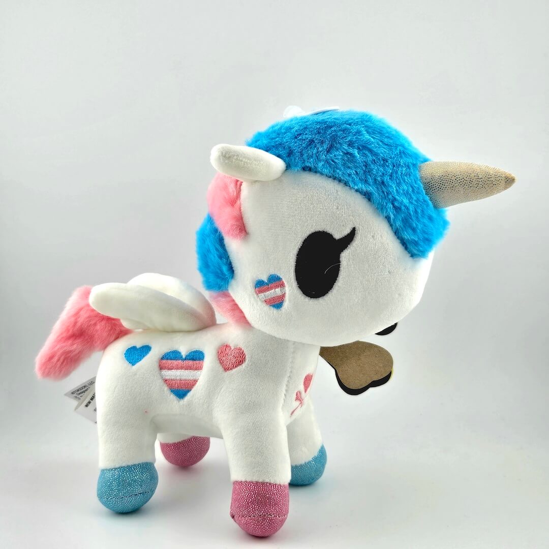 Plush toy with blue hair, pink wings, and heart patterns on a white background