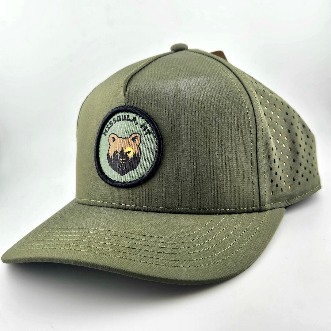 Green baseball cap with a bear patch on a white background