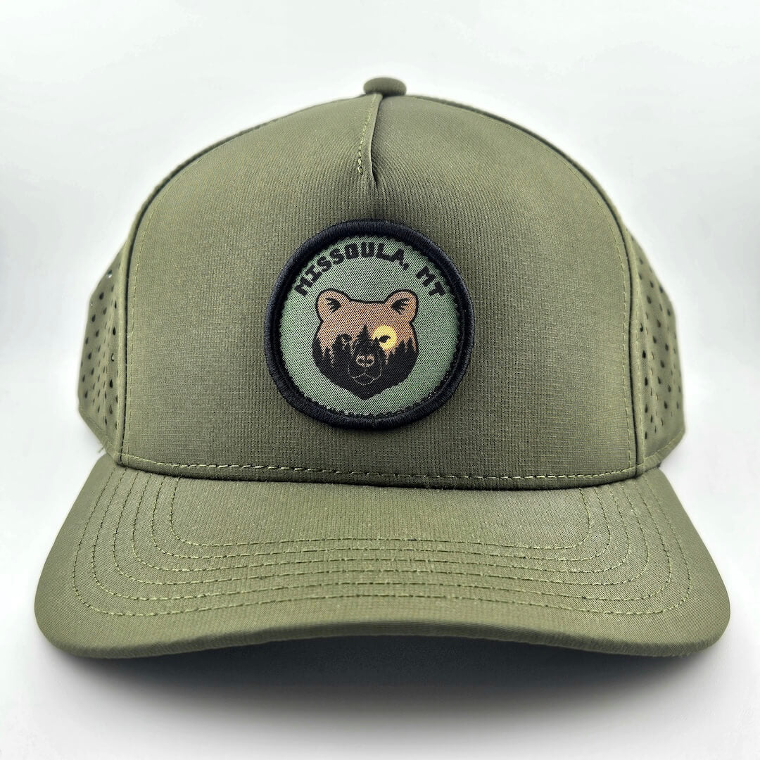 Green cap with bear patch and text on a white background