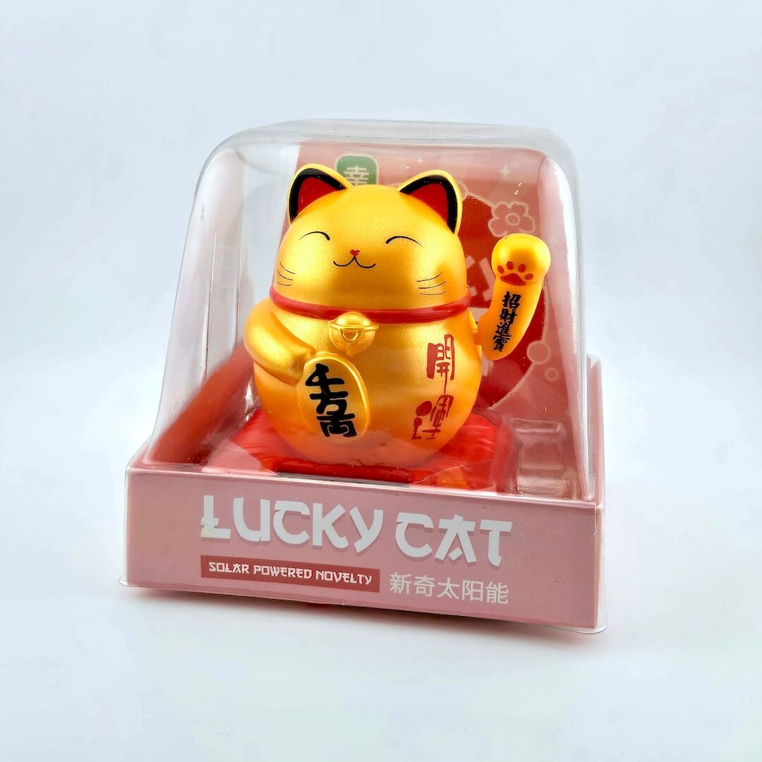 Gold lucky cat figurine in packaging with 'Lucky Cat' text on a light gray background