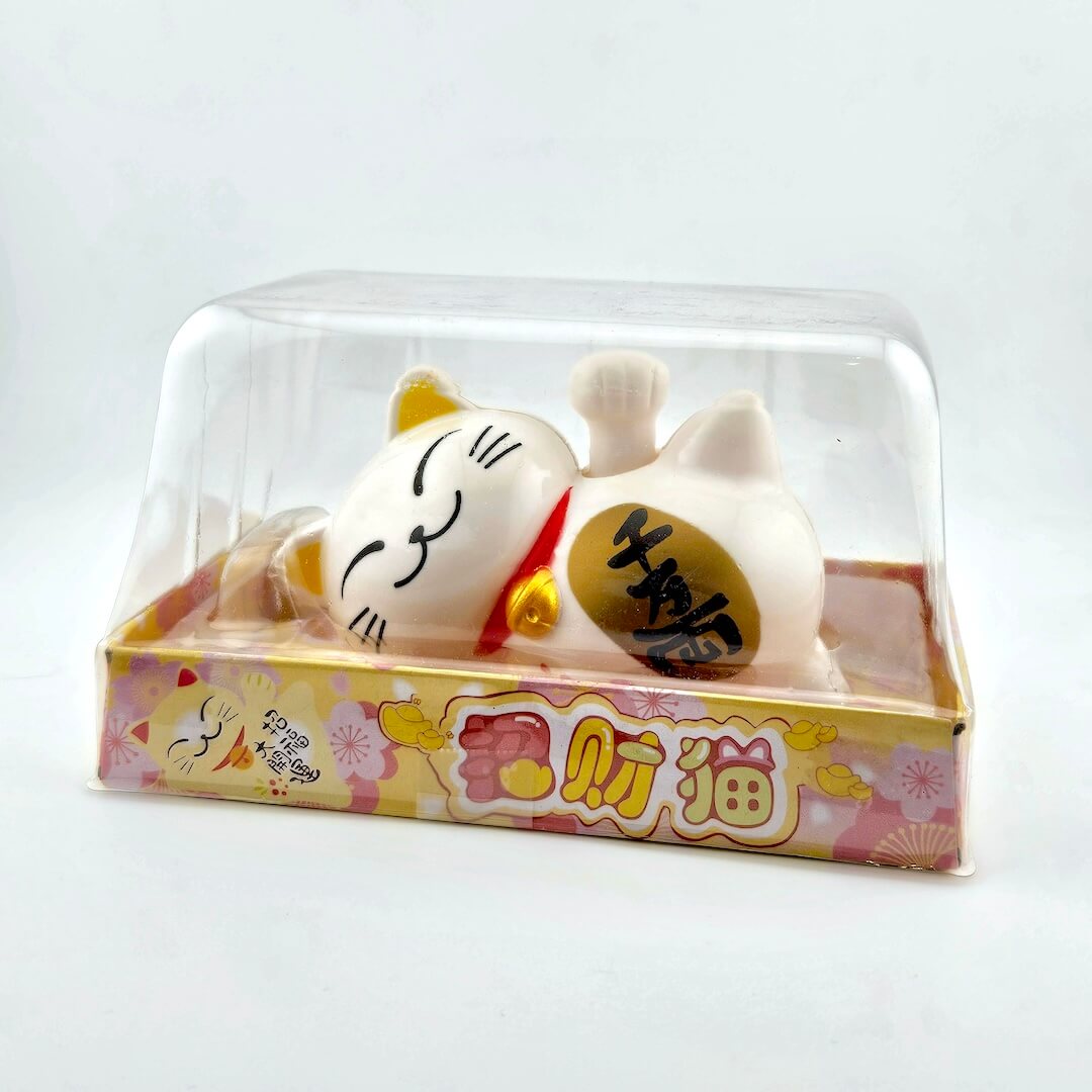 Decorative cat figurine with a clear plastic cover on a white background