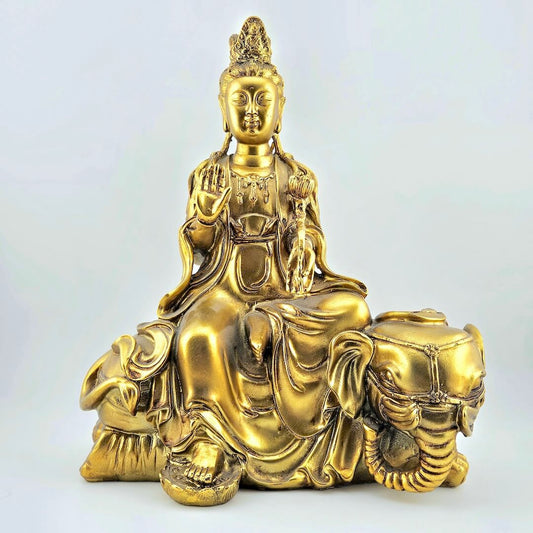 Gold-colored statue of a seated figure on a white background