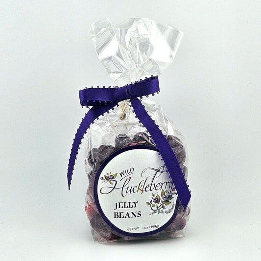 Clear plastic bag with purple ribbon. White circle label with painted huckleberries framing product name.