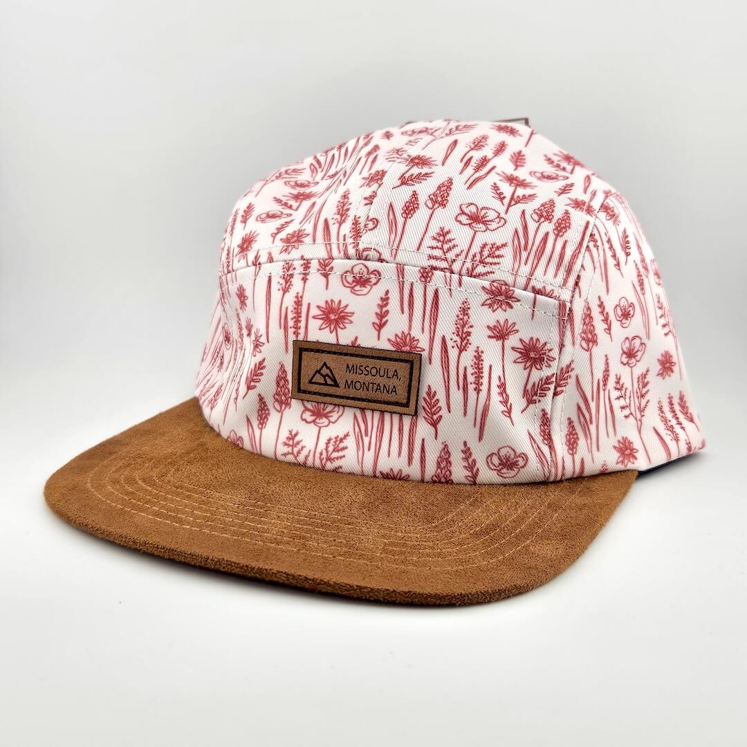 Cap with floral pattern and brown brim on a light gray background