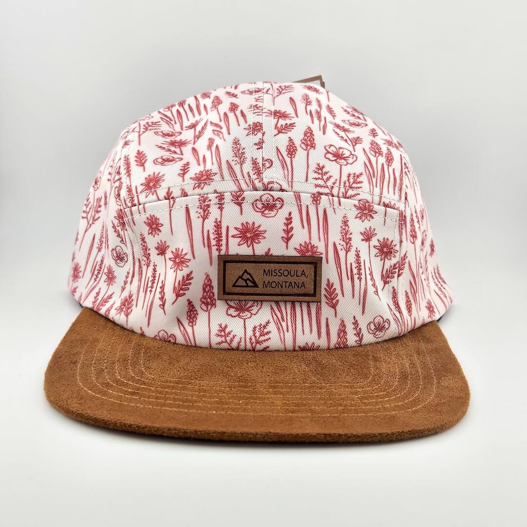 Cap with red floral pattern and brown brim on a light gray background