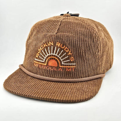 Brown corduroy billed hat with "ROCKIN RUDY'S", radiating from sunburst, "MISSOULA, MONTANA" along horizon bottom.