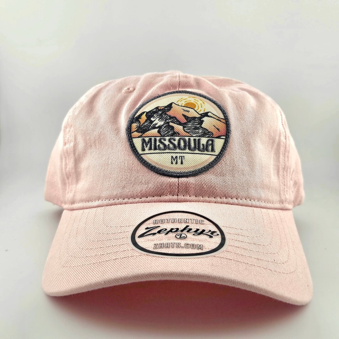 Pink cap with 'Missoula MT' and Zephyr branding on a light gray background