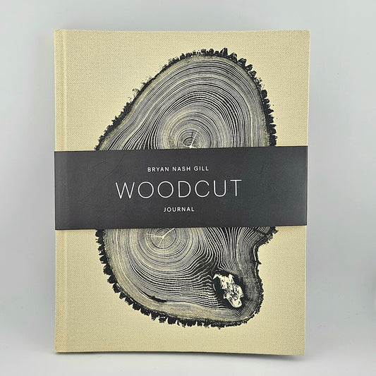 Journal with woodcut design on cover and black band with 'Bryan Nash Gill Woodcut Journal' text.