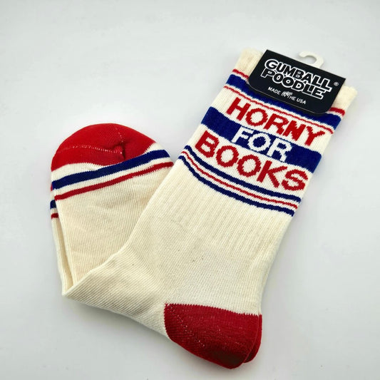 Beige socks with red toes and heels, with red and navy stripes with text, "Horny for Books."