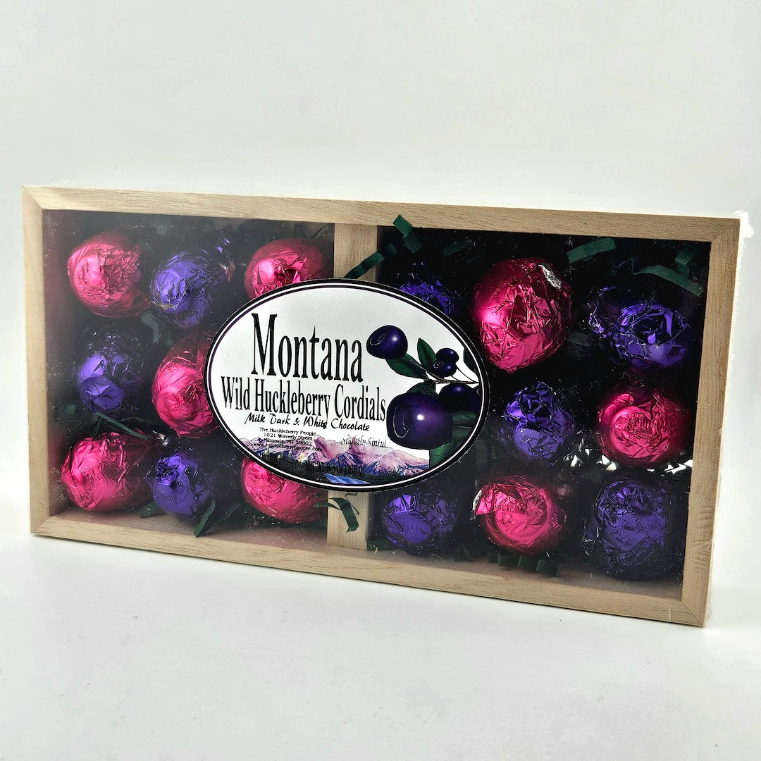Box of Montana Wild Huckleberry Cordials with colorful bottles on a white background