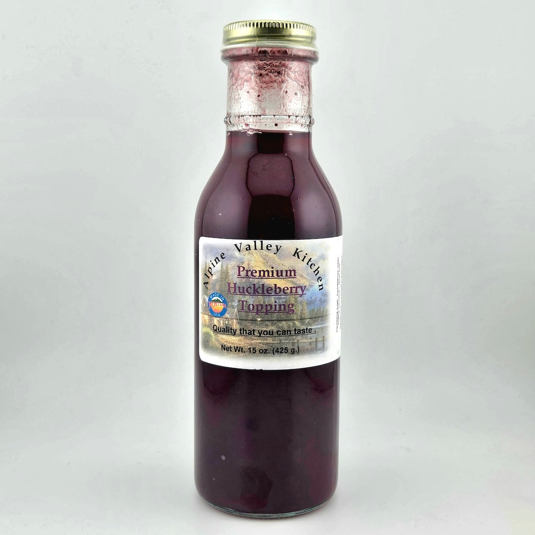 Bottle of Alpine Valley Kitchen huckleberry topping on a white background
