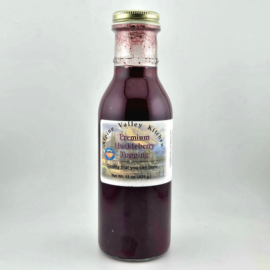 Bottle of Alpine Valley Kitchen huckleberry topping on a white background