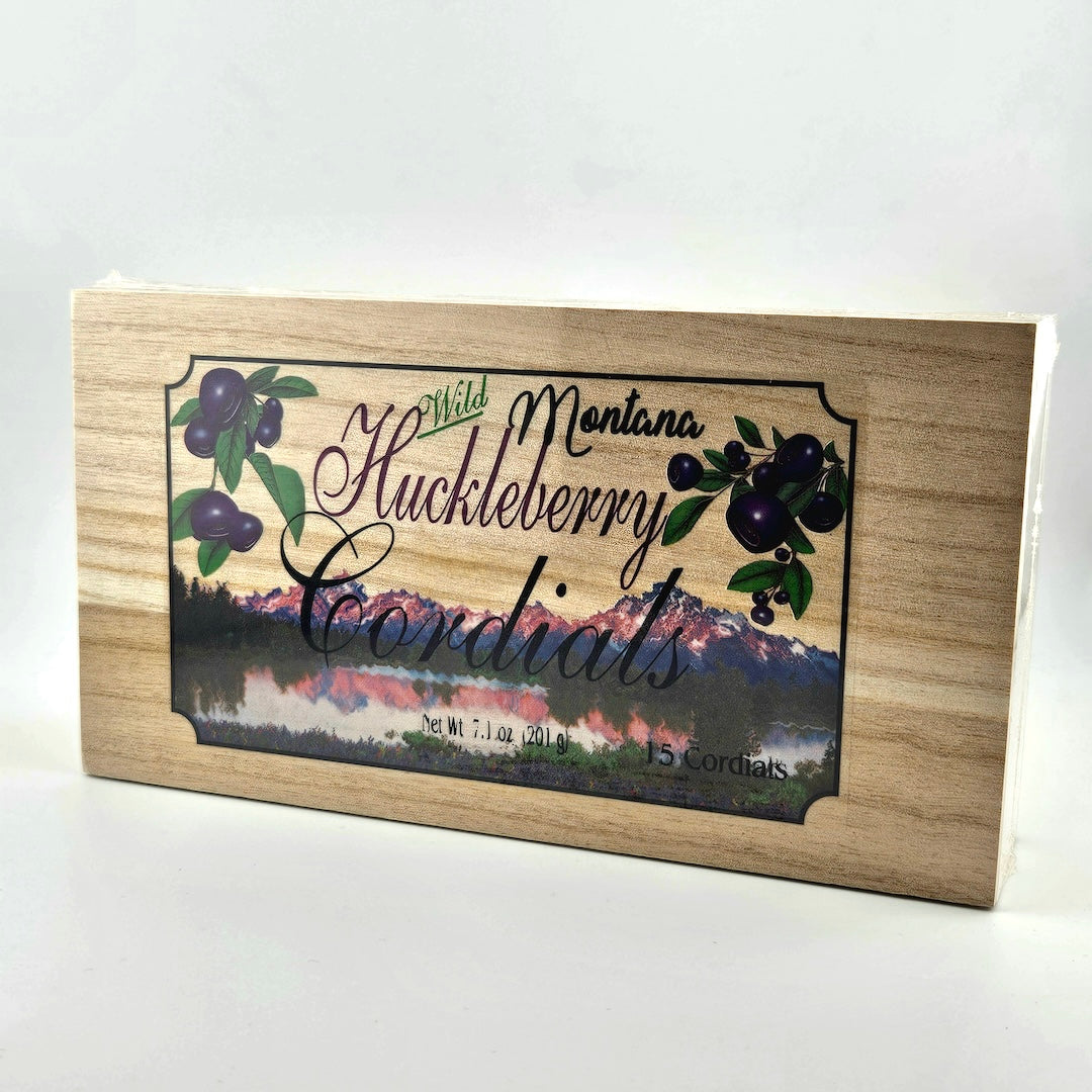 Wooden box with huckleberry design and mountain landscape on a white background